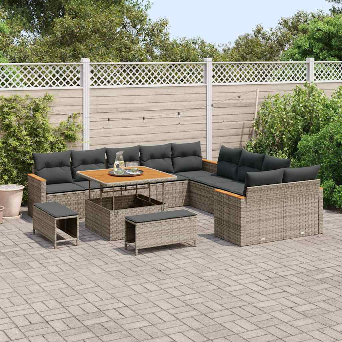 Garten-Terrassenset mit grauen Kissen und einem Holztisch. Ein weißer Zaun und Grün in der Hintergrund. Gepflasterte Terrasse.