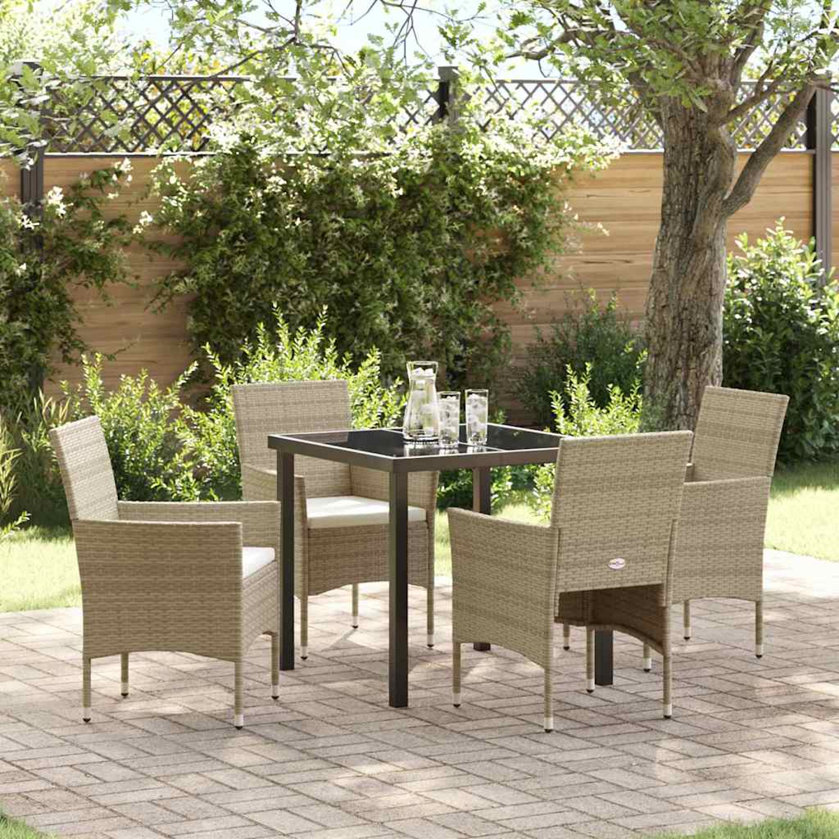 Set da patio all'aperto con tavolo quadrato, quattro sedie e bevande. Un albero e una siepe sullo sfondo, il tutto su un patio in mattoni.