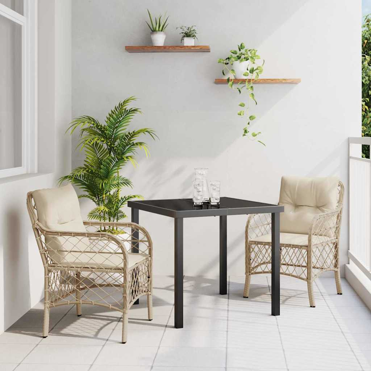 Ein Balkon mit Tisch, zwei Stühlen und Pflanzen. Der Tisch ist schwarz. Stühle sind geflochten. Pflanzen sind auf Regalen und in Töpfen.