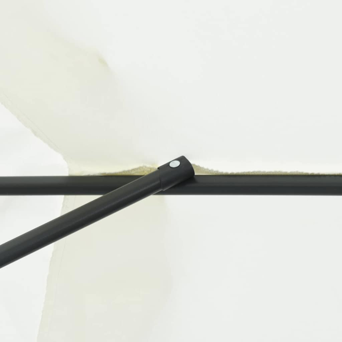 Primo piano di un'asta di supporto in metallo nero con sfondo in tessuto bianco. L'asta ha un pezzo di collegamento con un bottone argentato.