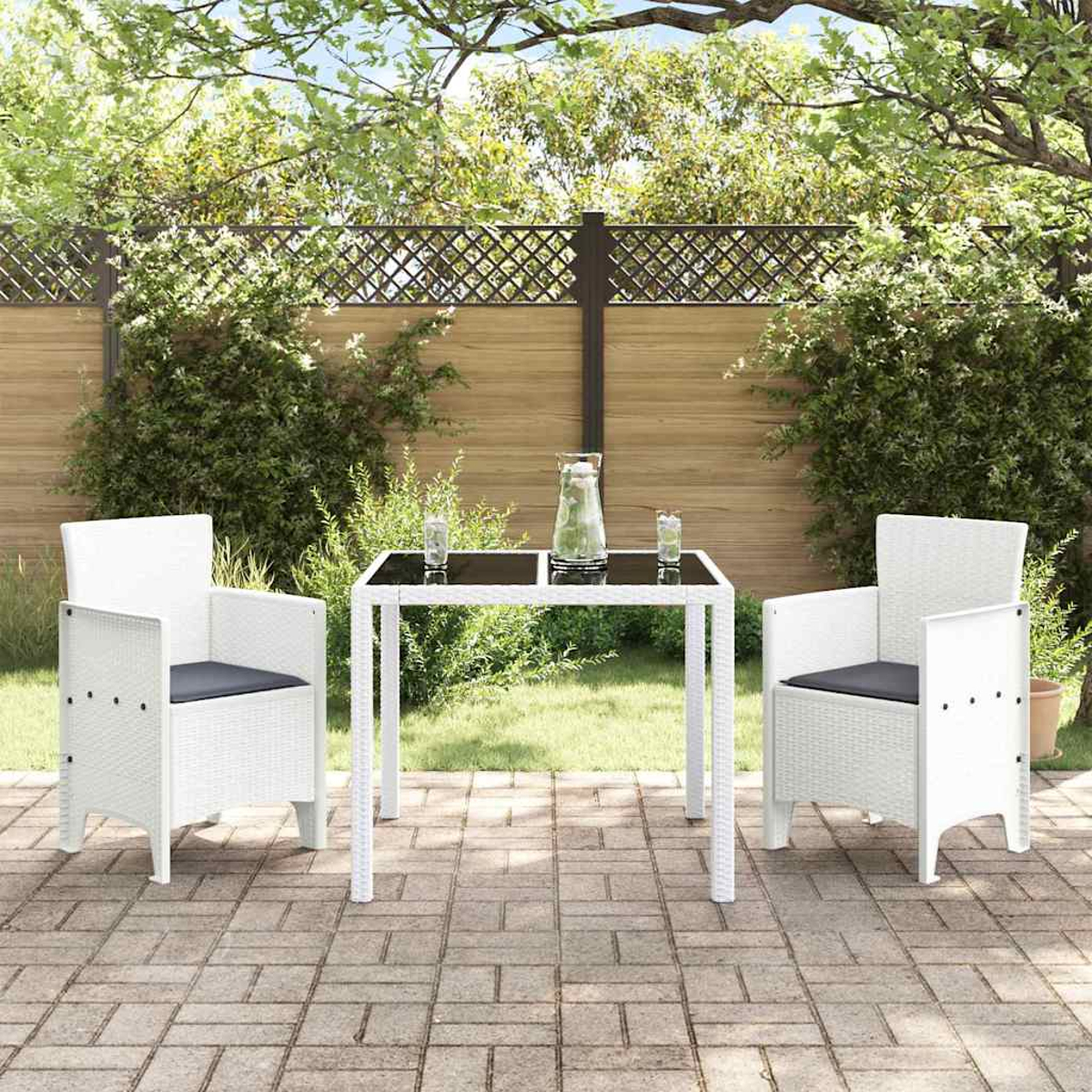 Szene auf der Terrasse mit weißen Stühlen und einem Tisch. Ein Glas Wasser auf dem Tisch. Grünes Gras und Pflanzen, ein Holzzaun im Hintergrund.