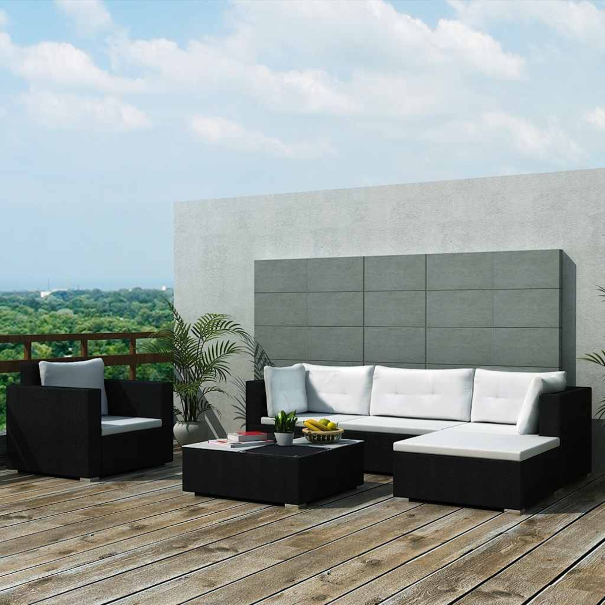 Gartenmöbel-Set: schwarzes Sofa, Stuhl und Couchtisch mit weißen Kissen. Grüne Bäume und blauer Himmel im Hintergrund.
