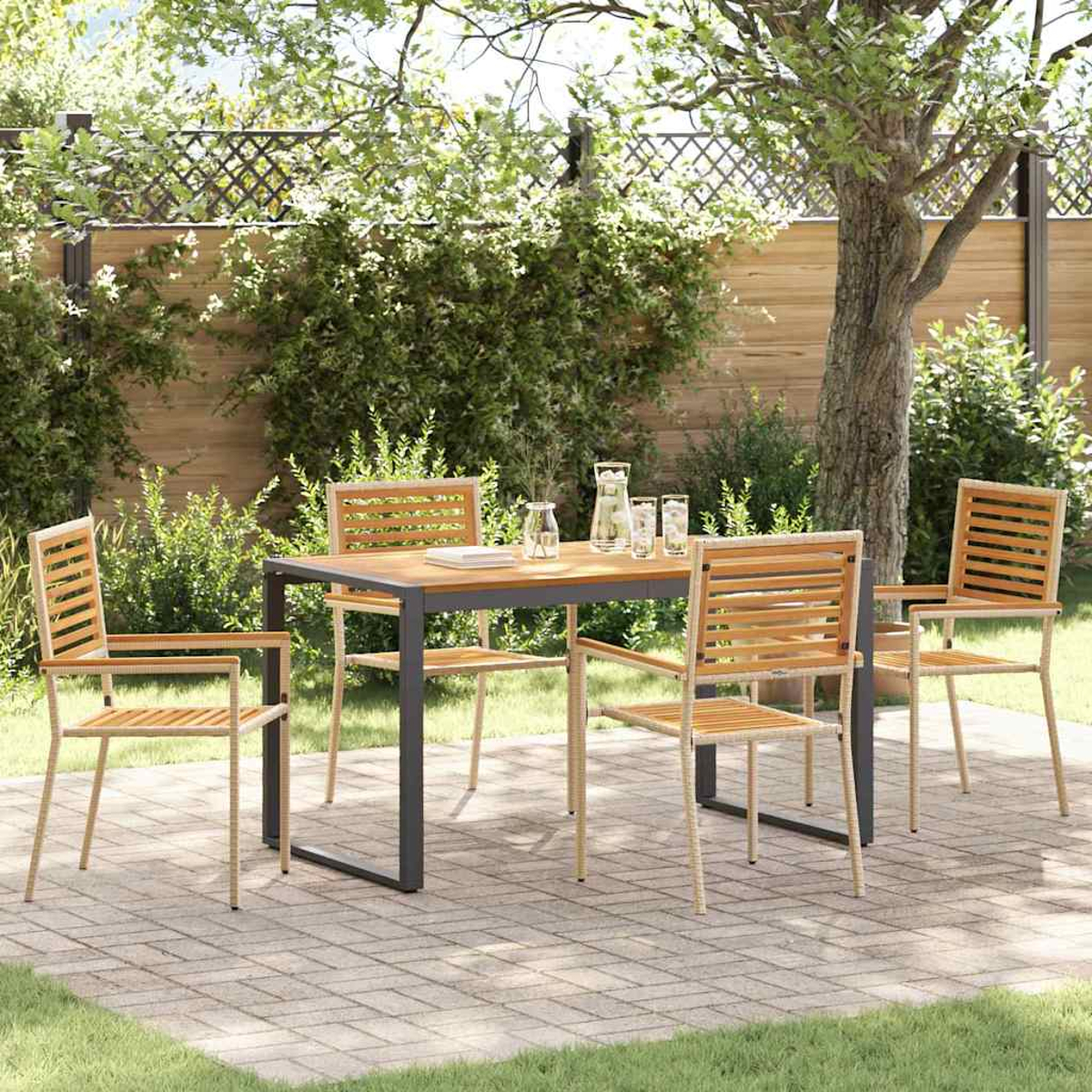 Juego de comedor al aire libre: mesa y sillas en el patio. Mesa de madera, marco gris, cuatro sillas, bebidas. Césped verde y árboles al fondo.
