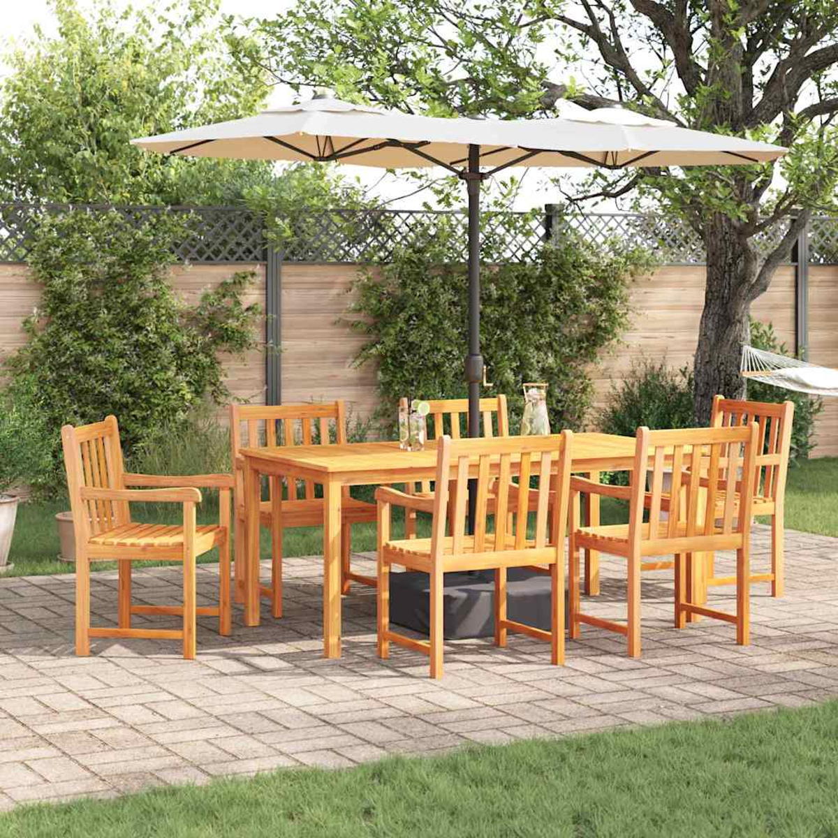 Holz-Terrassenset mit Tisch, sechs Stühlen und Sonnenschirm. Auf einer Backstein-Terrasse mit grünem Gras und Bäumen im Hintergrund.