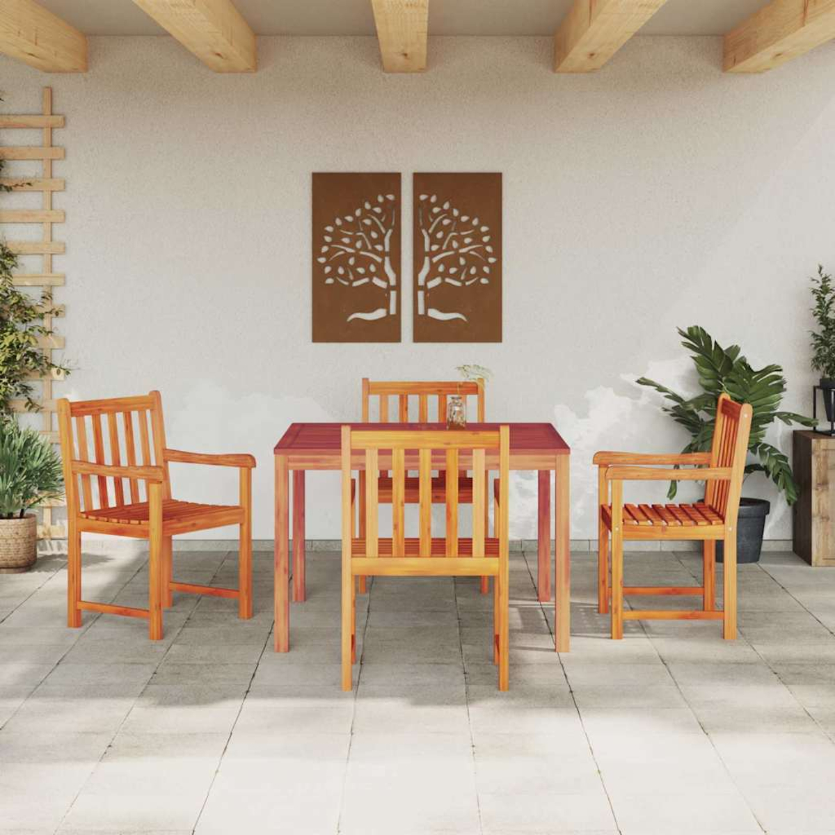 Essgruppe im Freien mit Holztisch und Stühlen. Zwei Baumkunstwerke an der Wand. Pflanzen und ein Spalier ergänzen die Szene.