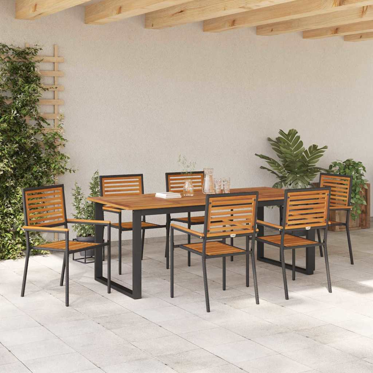 Essgarnitur im Freien mit Holztisch und Stühlen auf einer Terrasse. Pflanzen und Holzbalken sind im Hintergrund. Klare Gläser auf dem Tisch.