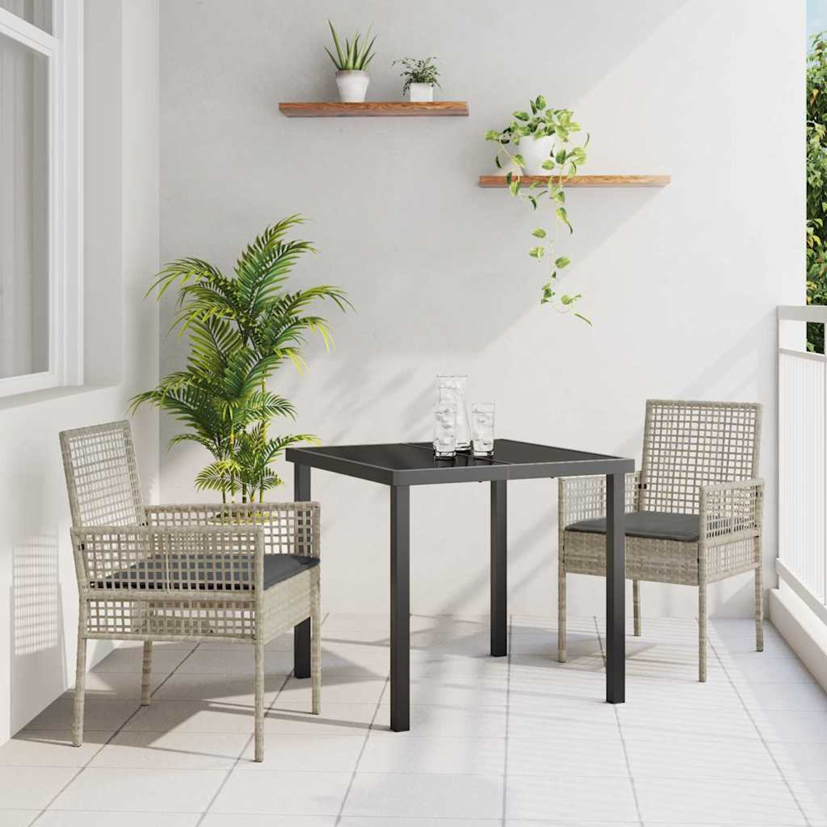Szene im Freien mit Tisch, Stühlen und Pflanzen. Der Tisch hat eine schwarze Oberfläche. Stühle sind gewebt. Pflanzen auf Regalen und in Töpfen.