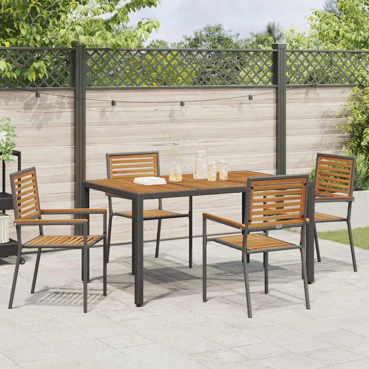 Garten-Essgruppe: Tisch und Stühle auf der Terrasse. Holztisch und Stühle, graue Metallrahmen. Hintergrund: Zaun, Bäume und Himmel.