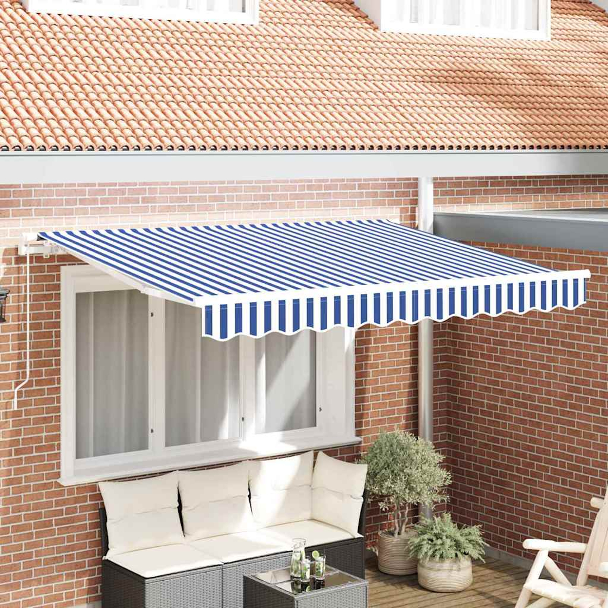 Ein blau-weiß gestreifter Markisen überdeckt ein Fenster. Darunter befinden sich eine Backsteinmauer und Gartenmöbel. Oben ist ein Ziegeldach.
