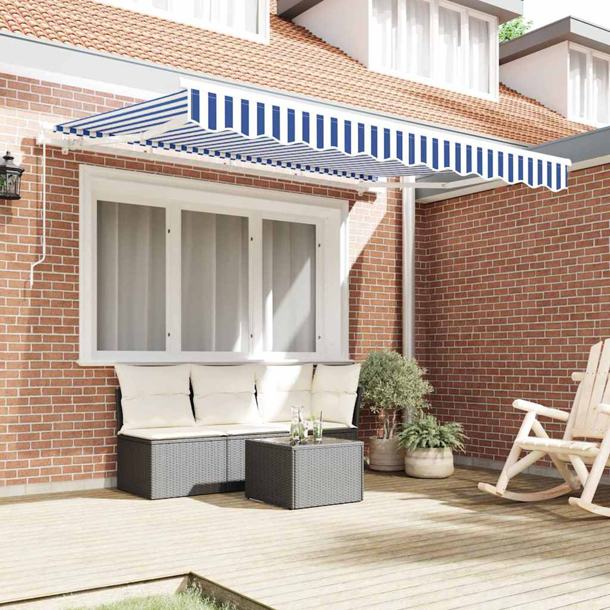 Eine Terrasse mit blau-weiß gestreifter Markise, Backsteinmauer, Sofa, Tisch, Pflanzen und einem Schaukelstuhl.