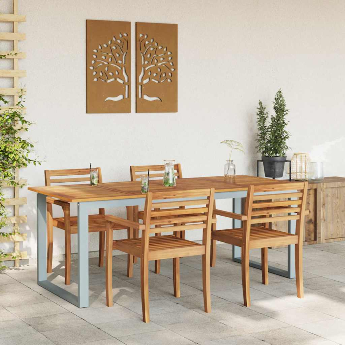 Set da pranzo all'aperto: tavolo e sedie in legno. Due opere d'arte ad albero sulla parete. Piante in vaso, mobile e bevande.