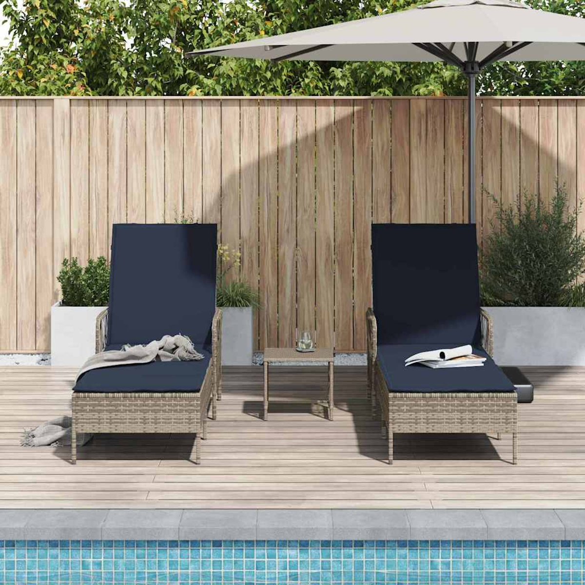 Zwei Liegestühle mit marineblauen Kissen stehen auf einem Deck am Pool. Ein kleiner Tisch und ein Sonnenschirm vervollständigen die Szene.