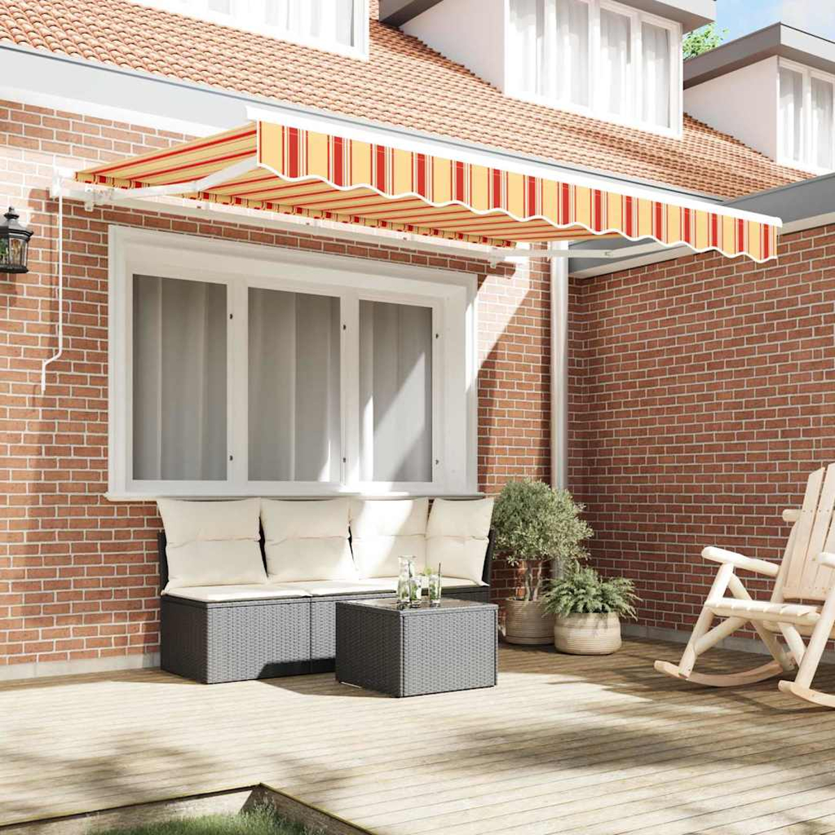 Eine Terrasse mit roter Backsteinmauer, Markise, Sitzgelegenheiten und Schaukelstuhl. Pflanzen in Töpfen sind ebenfalls zu sehen. Die Markise hat rot-gelbe Streifen.