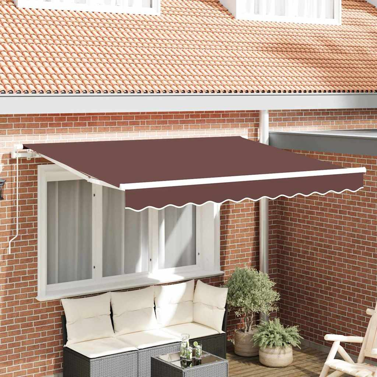 Eine braune Markise erstreckt sich über eine Terrasse mit Sofa, Tisch und Pflanzen. Eine rote Backsteinmauer und ein Ziegeldach sind im Hintergrund.