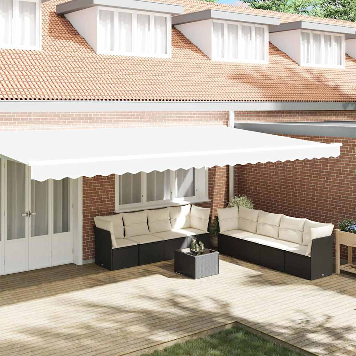 Terrasse im Freien mit weißer Markise, Sitzgelegenheiten und Tisch. Rote Backsteinmauer und Dach mit Fenstern im Hintergrund.