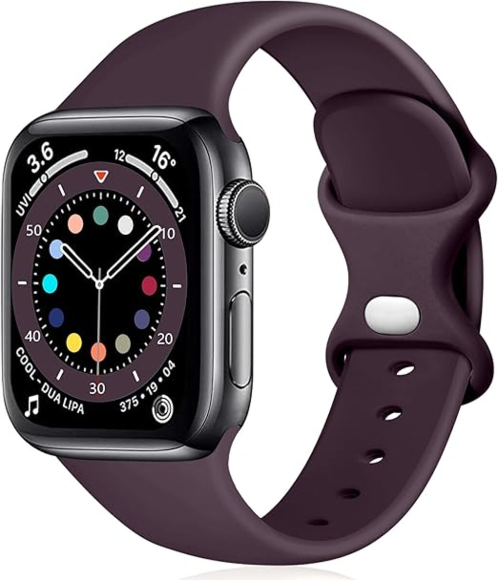 Eine dunkelgraue Apple Watch mit einem pflaumenfarbenen Armband. Das Zifferblatt zeigt die Uhrzeit und farbige Indikatoren. Das Armband ist gebogen.