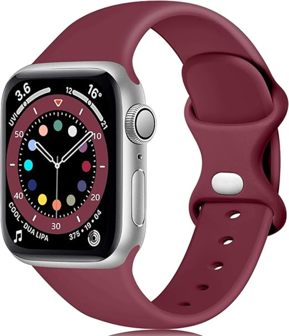 Eine silberne Apple Watch mit einem weinroten Armband. Das Zifferblatt zeigt die Uhrzeit sowie farbige Indikatoren. Das Armband ist geschlungen.