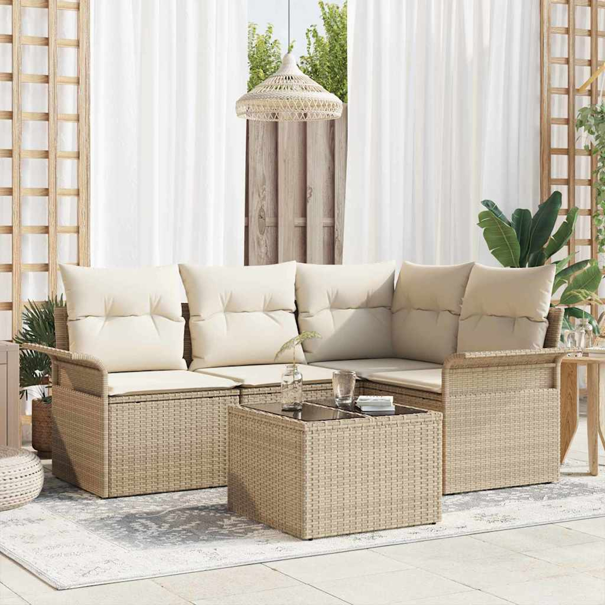 Ein beiges Outdoor-Ecksofa aus Korbgeflecht mit cremefarbenen Kissen und einem passenden Couchtisch. Die Szene spielt auf einer Terrasse mit weißen Vorhängen.