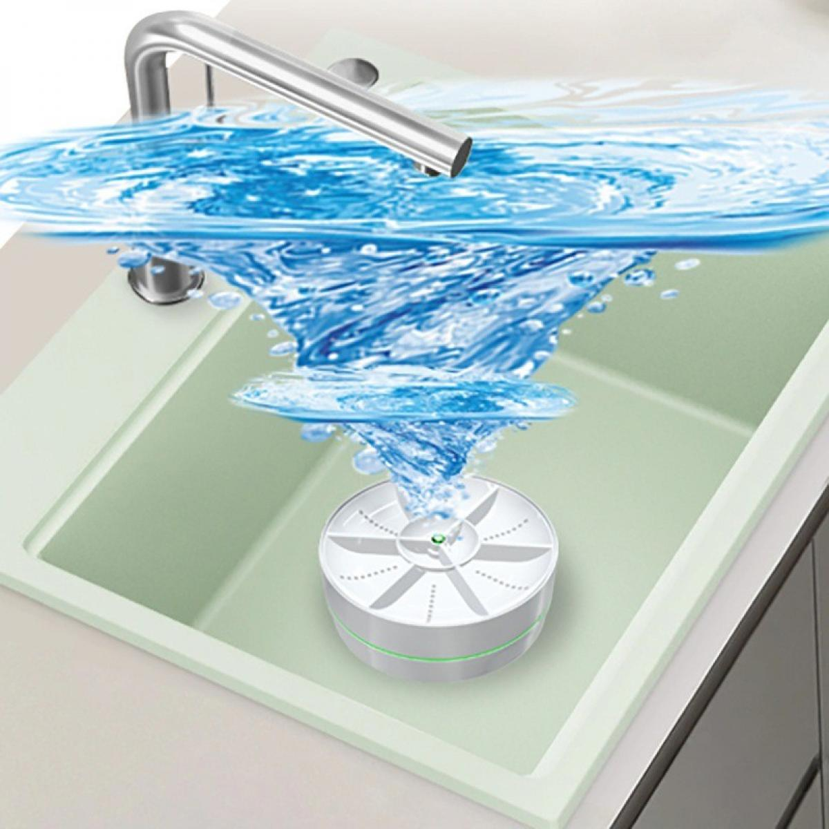 Ein Waschbecken mit einem Wasserhahn, der Wasser gießt. Ein Gerät wirbelt Wasser auf. Das Wasser ist blau. Waschbecken und Gerät sind weiß und grün.