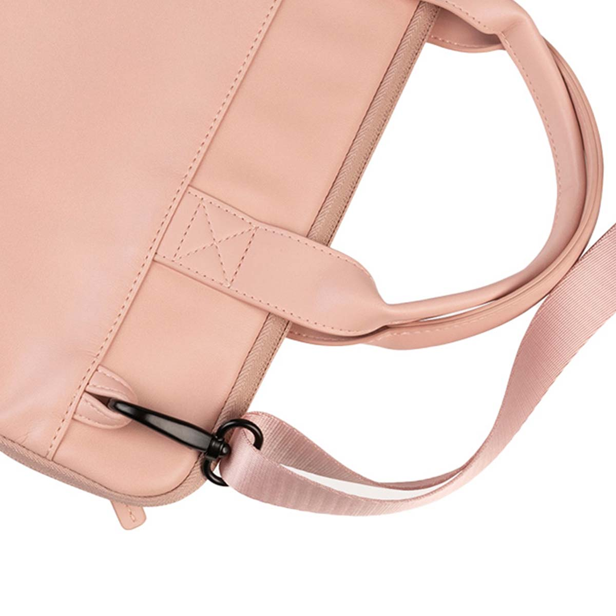 Primo piano di una borsa in pelle rosa con manico, tracolla e chiusura nera. La borsa è su sfondo bianco.