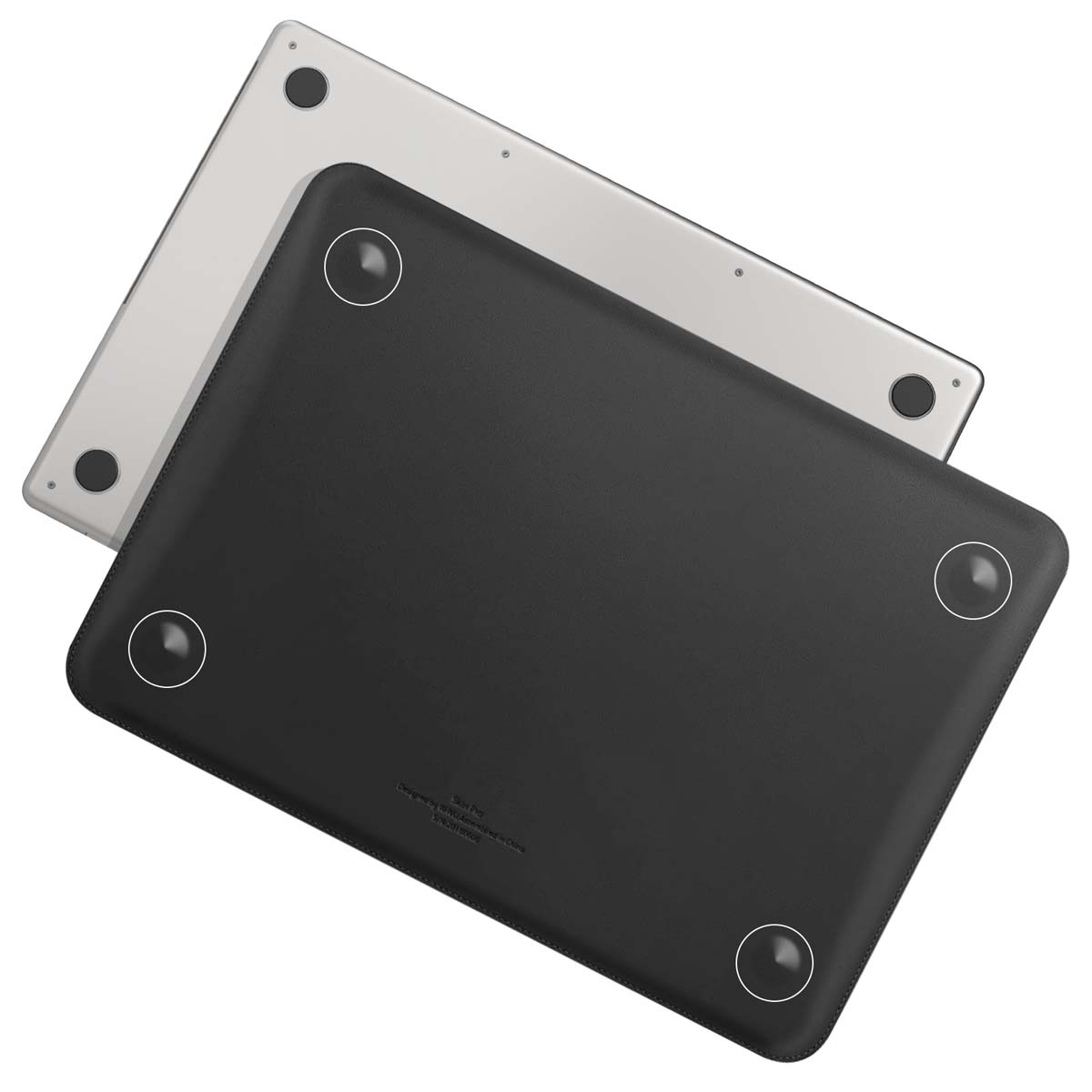 Un étui d'ordinateur portable noir est posé sur un ordinateur portable argenté. L'étui a des cercles blancs et du texte. Les ordinateurs portables sont sur une surface blanche.