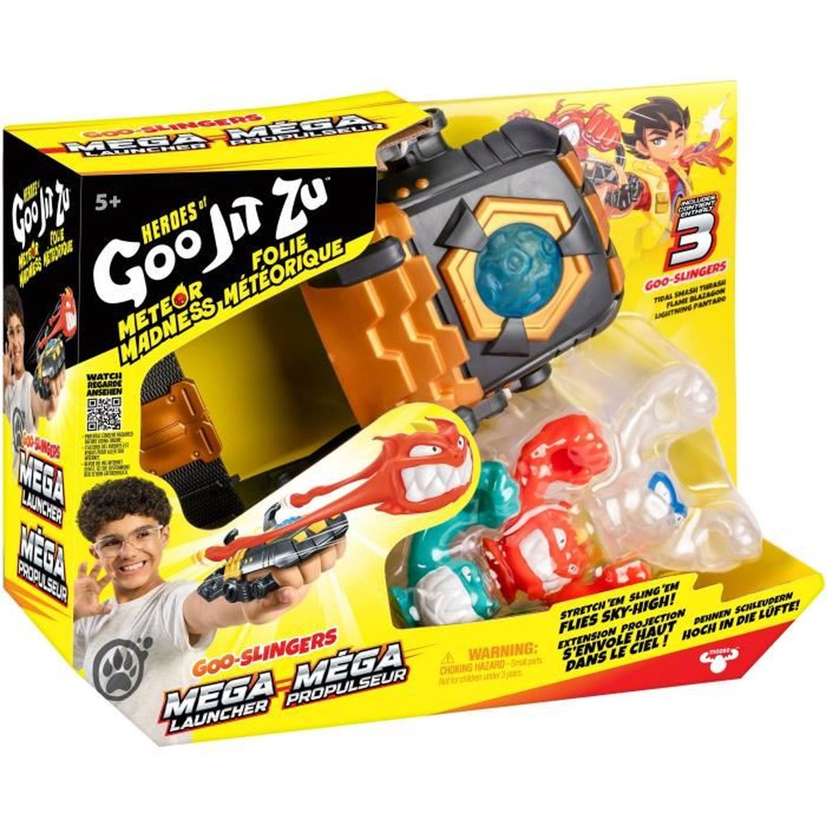 Eine Spielzeugkiste mit einem Werfer und drei Figuren. Ein Junge hält ein Spielzeug. Text sagt Goo Jit Zu Mega Mega Launcher.
