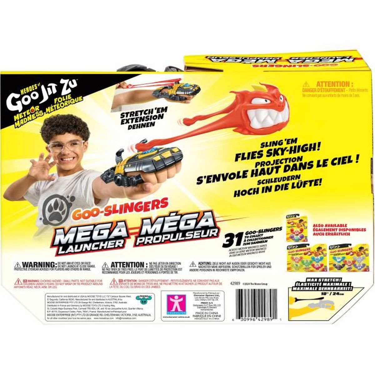 Ein Junge mit Brille hält eine Goo Jit Zu Spielzeugkiste. Es hat Text und Bilder der Spielzeuge. Rotes Spielzeug wird gestartet.