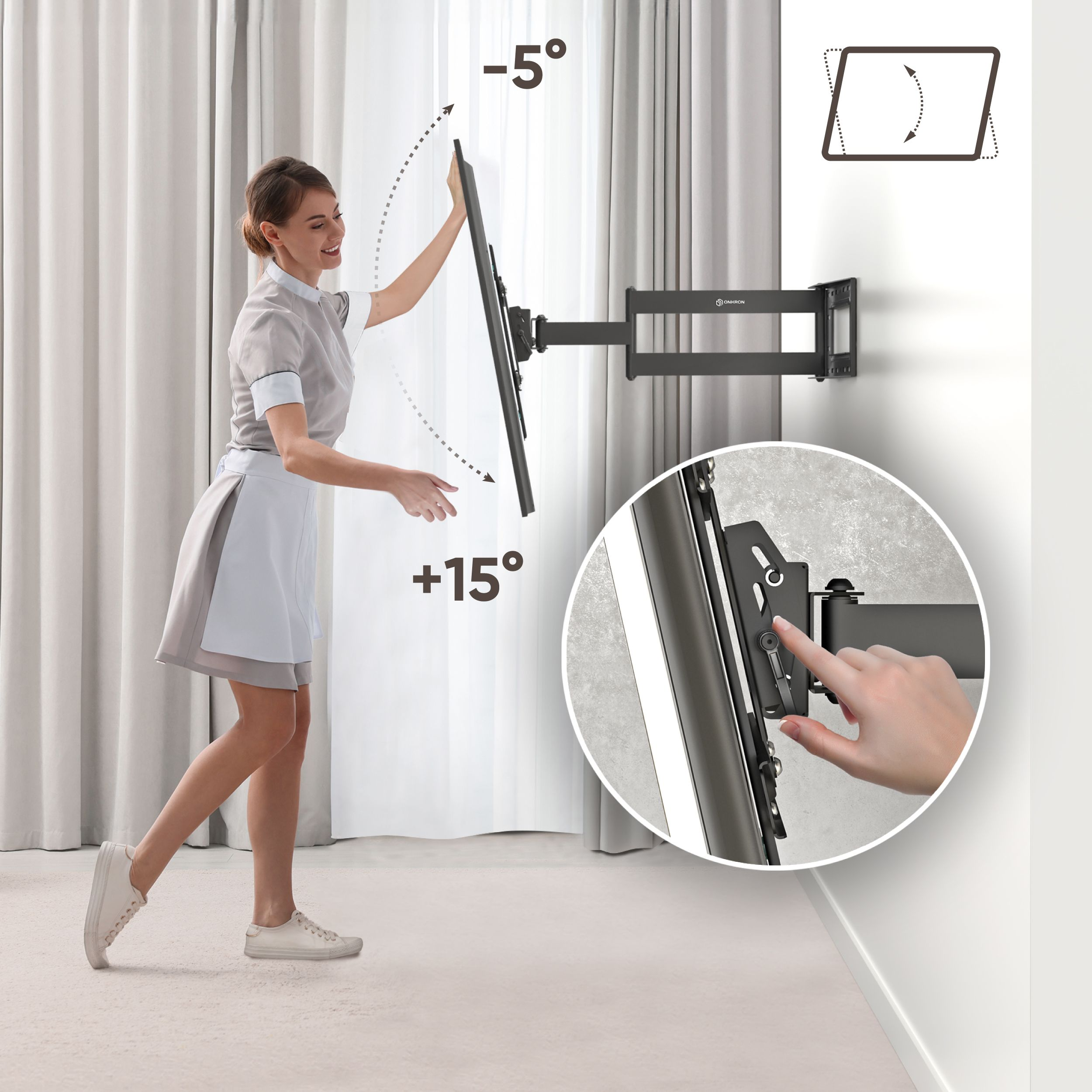 Kobieta w mundurze reguluje telewizor na czarnym uchwycie ściennym. Ściana jest biała. Telewizor można przechylać.