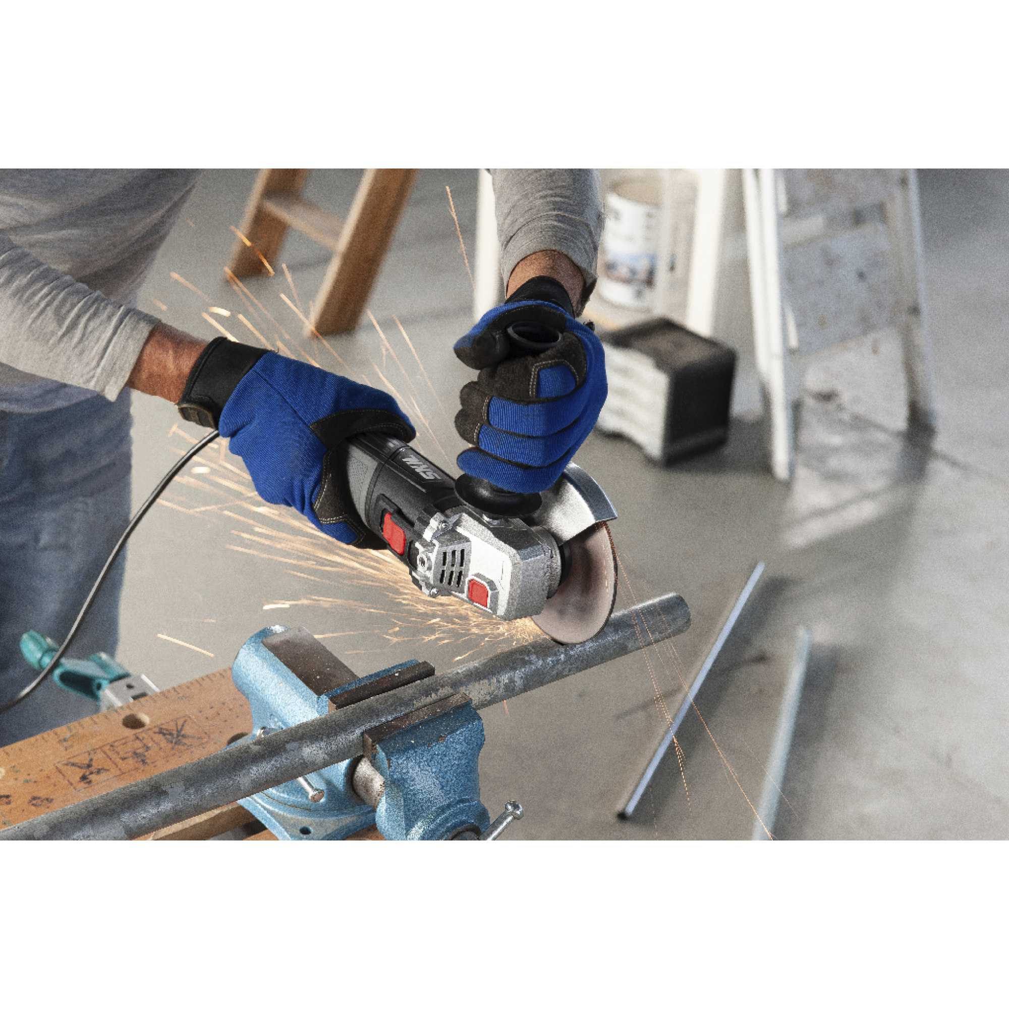 Eine Person schleift ein Metallrohr mit einem Winkelschleifer. Funken fliegen. Sie tragen blaue Handschuhe.