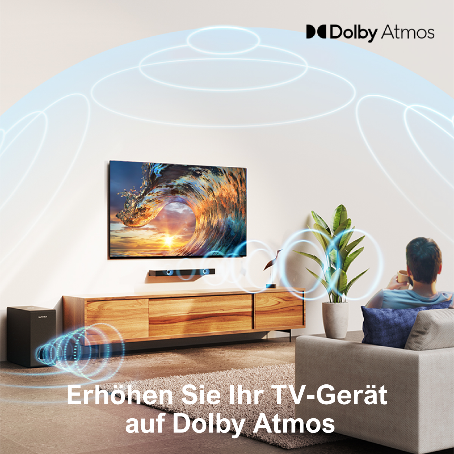 Ein Wohnzimmer mit Fernseher, Soundsystem und einer Person auf dem Sofa. Der Fernseher zeigt eine Welle. Dolby Atmos Logo sichtbar.