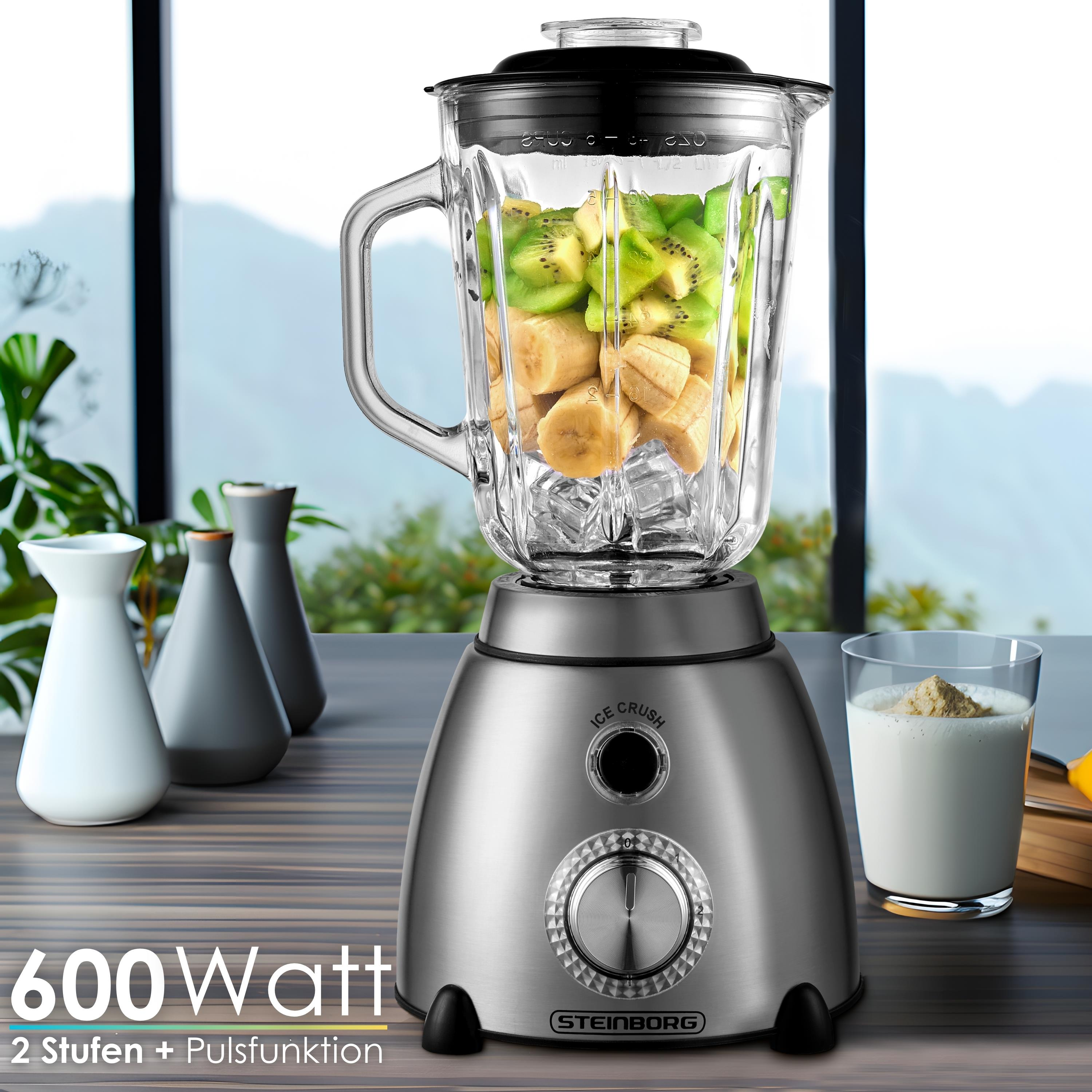 Ein Mixer mit Obst und Eis, daneben ein Glas Milch mit Pulver und Vasen.