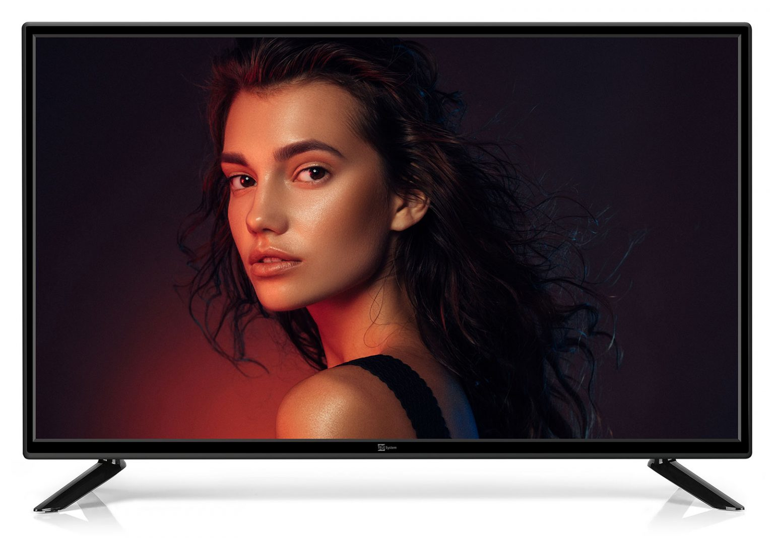 Il volto di una donna sullo schermo di una TV. Guarda sopra la spalla, illuminata da tonalità rosse e blu. La TV ha cornice e supporto neri.
