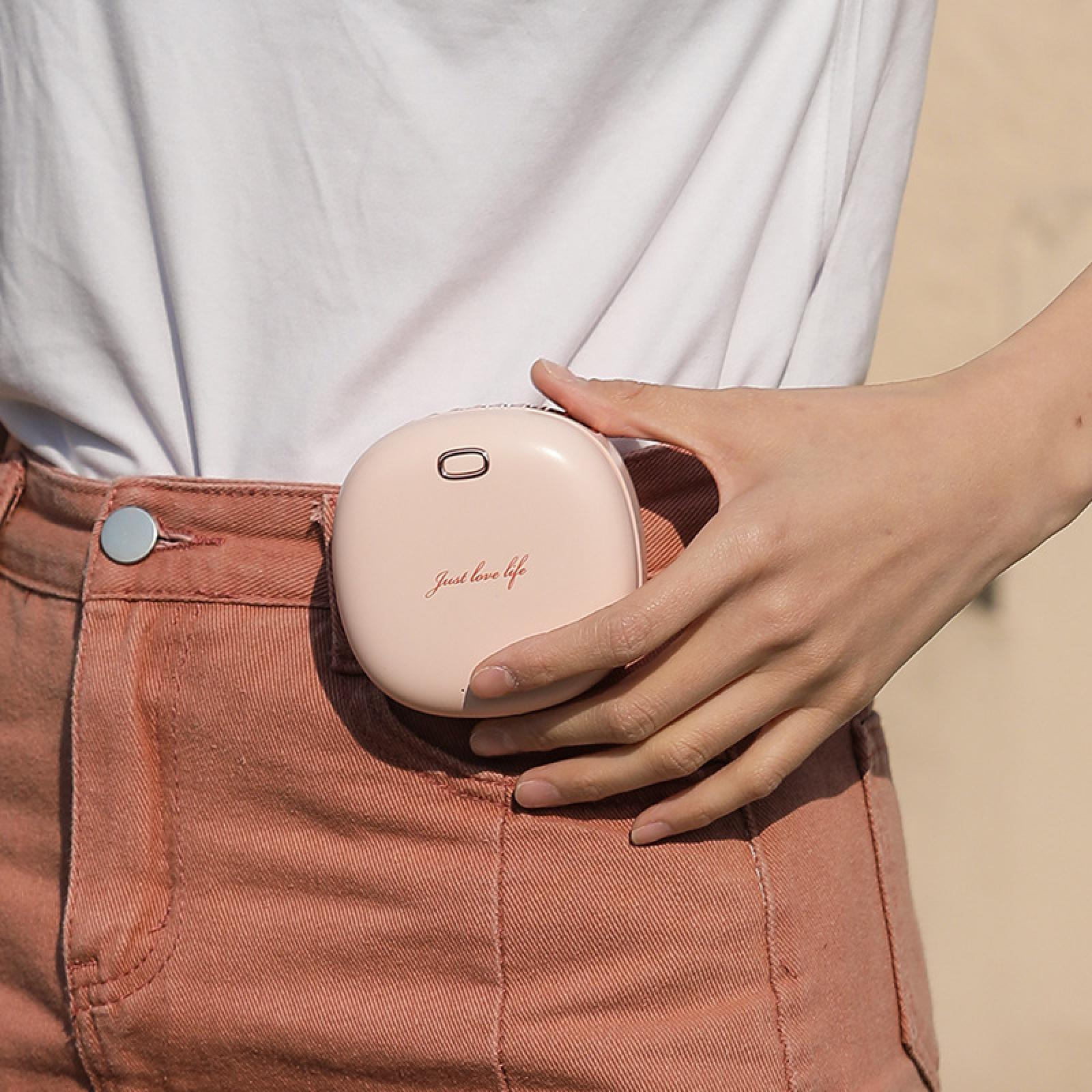 Eine Person hält ein rosa Gerät an ihrer Taille. Das Gerät trägt den Text 'Just love life'. Sie trägt ein weißes Hemd und eine rosa Hose.