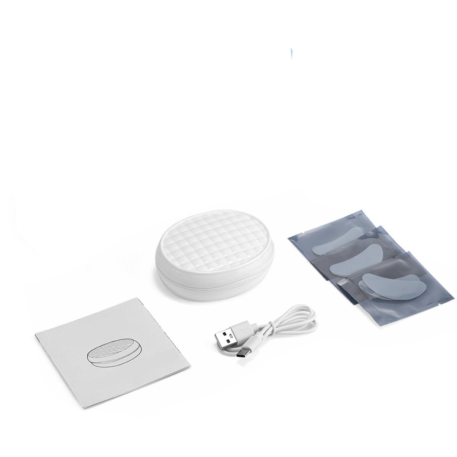 Das Bild zeigt ein weißes Augenmaskengerät, ein USB-Kabel, Augenpads und eine Anleitung auf weißem Hintergrund.