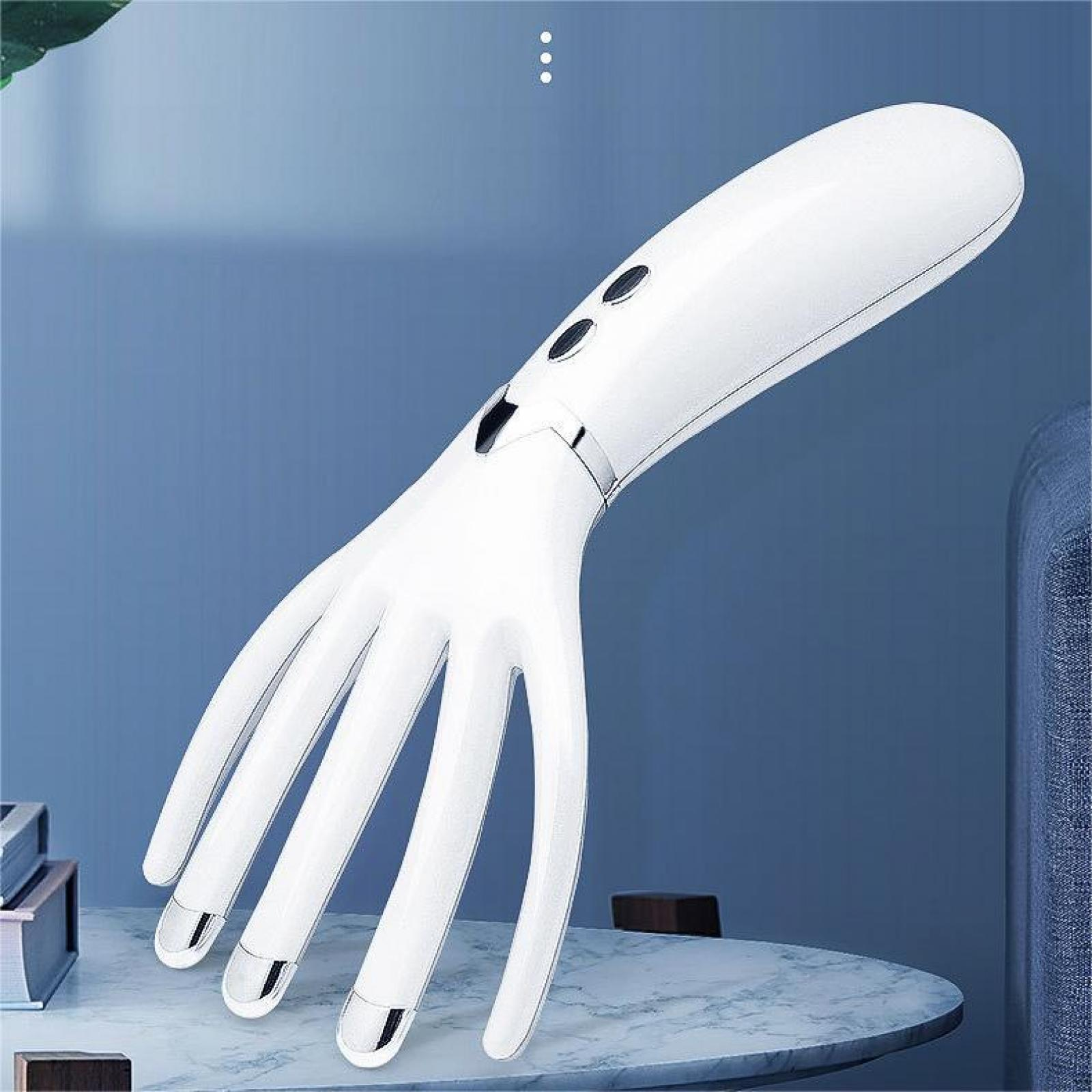 Weißes elektrisches Kopfhautmassagegerät mit fünf Zinken auf einem Marmortisch vor einer blauen Wand.
