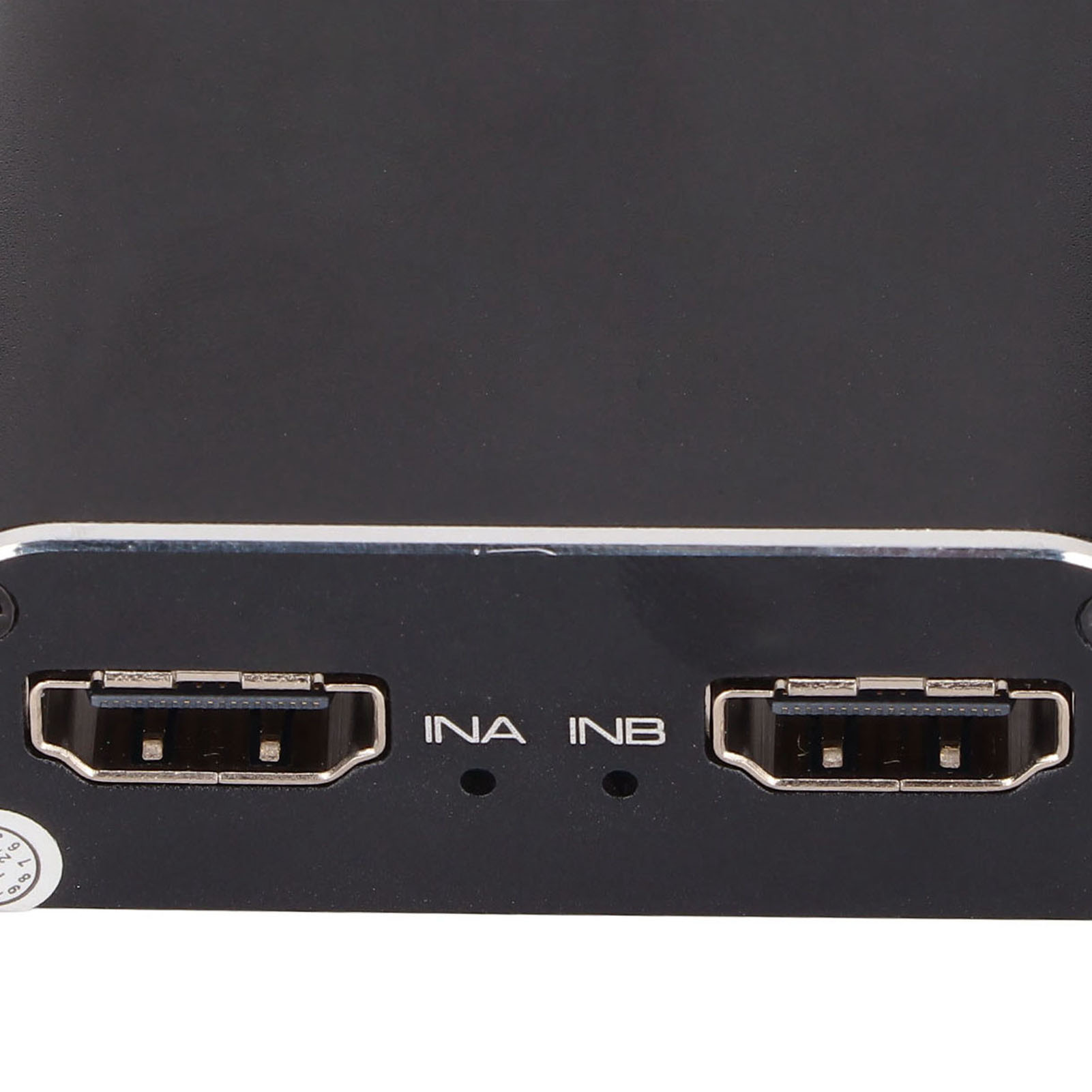Nahaufnahme eines schwarzen Geräts mit zwei HDMI-Anschlüssen mit der Bezeichnung INA und INB. Auf der linken unteren Ecke befindet sich ein kleiner Aufkleber.