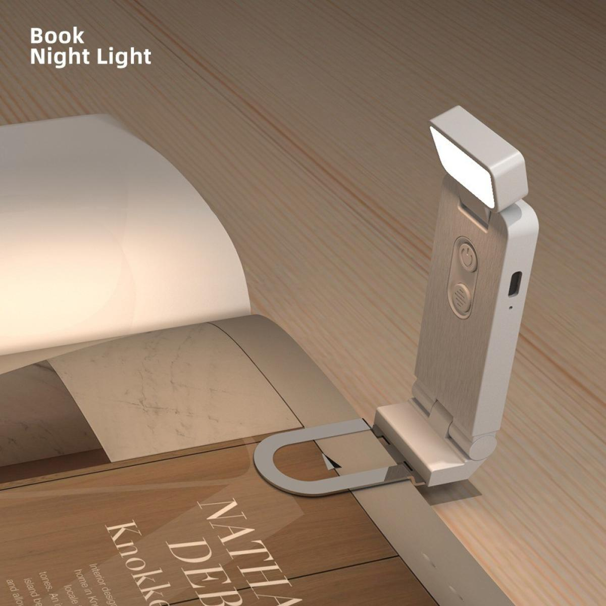 Ein Buch mit einer weißen Leselampe. Das Licht ist an und beleuchtet die Seiten. Das Buch liegt auf einer Holzoberfläche.