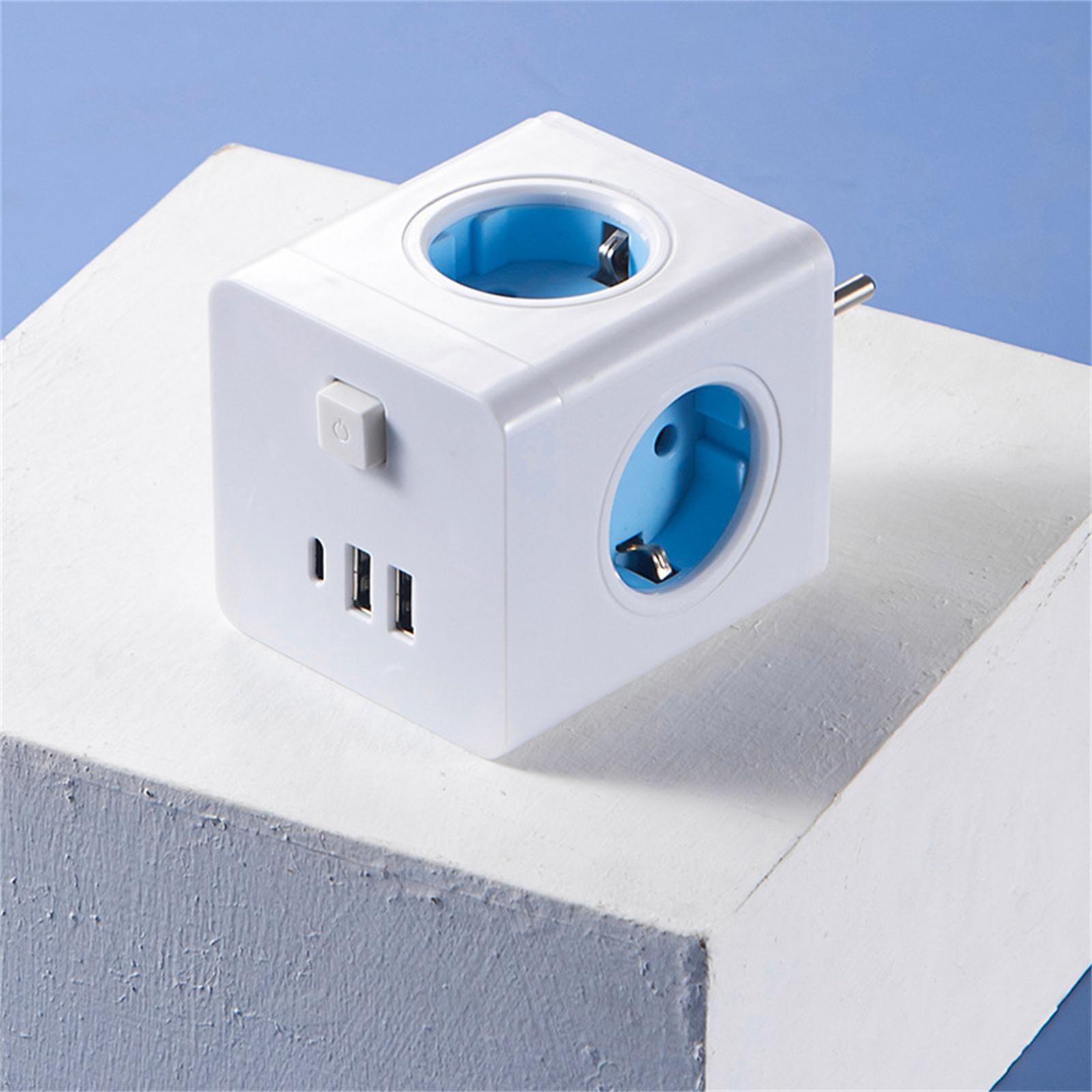 Ein weißer Würfel-Netzadapter mit blauen Steckdosen, USB-Anschlüssen und einem Ein-/Aus-Schalter, der auf einer weißen Oberfläche liegt.