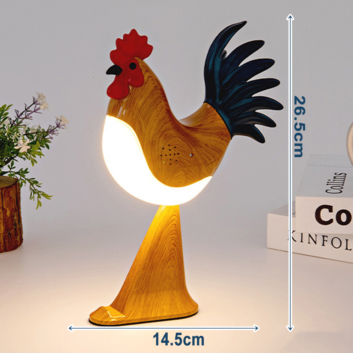 Eine holzgeschnitzte Hahn-Lampe steht auf einem Tisch. Sie hat einen roten Kamm, einen schwarzen Schwanz und ein weißes Licht. Maße: 26,5 cm hoch und 14,5 cm breit.