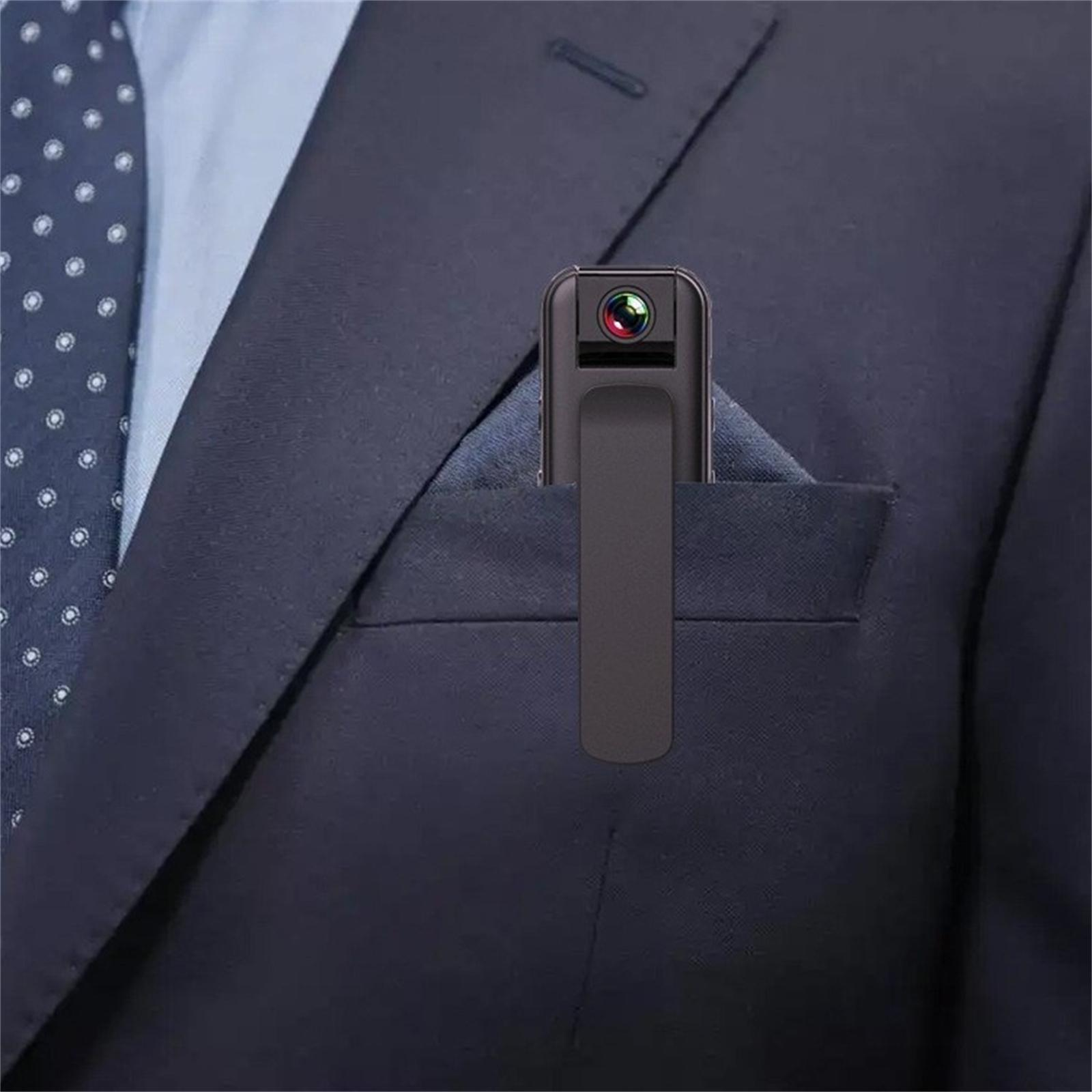 Eine kleine Kamera mit Clip steckt in einer Anzugtasche. Eine Krawatte mit weißen Punkten ist sichtbar.