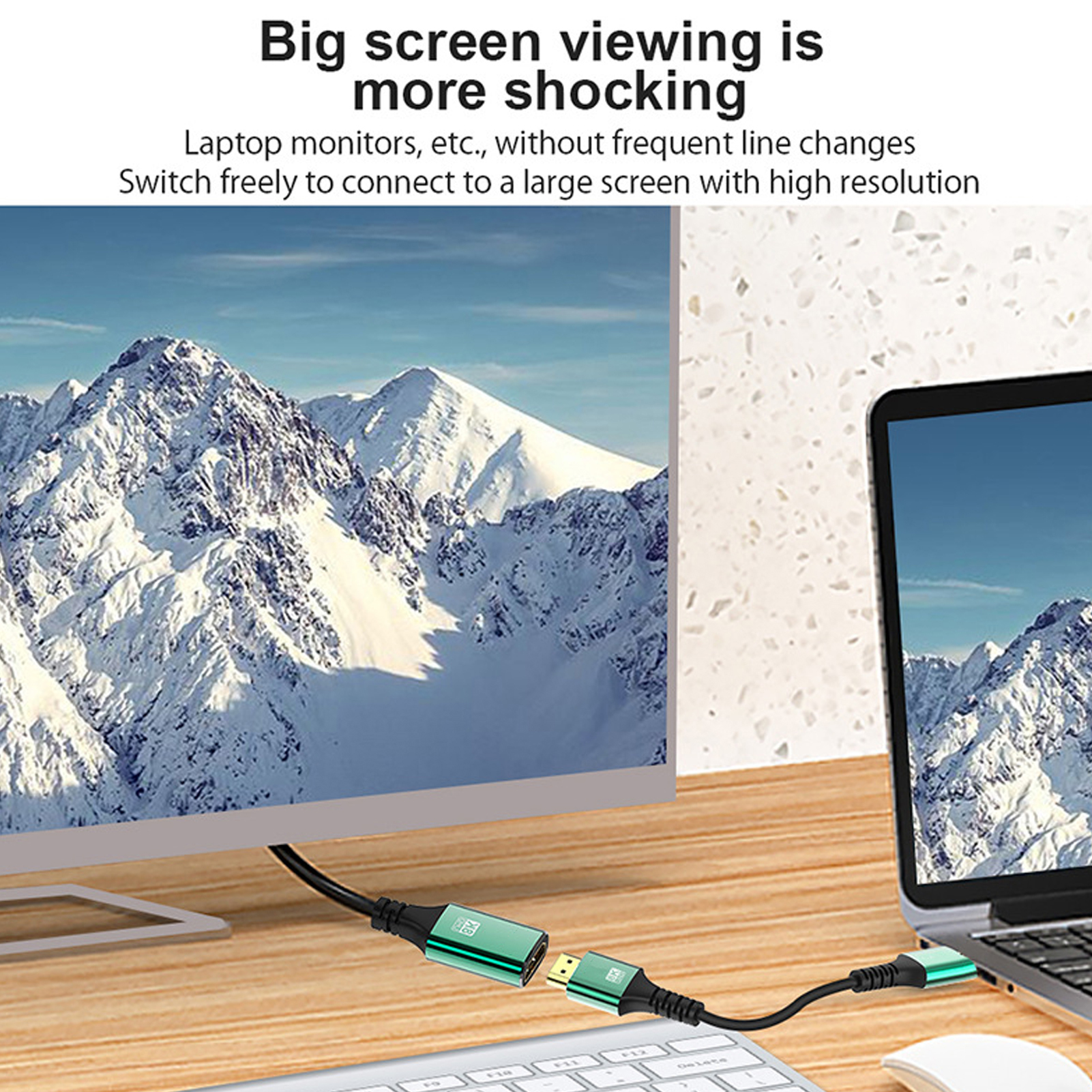 Ein Bild zeigt einen Monitor und einen Laptop, die durch ein grünes Kabel verbunden sind. Schneebedeckte Berge sind im Hintergrund.