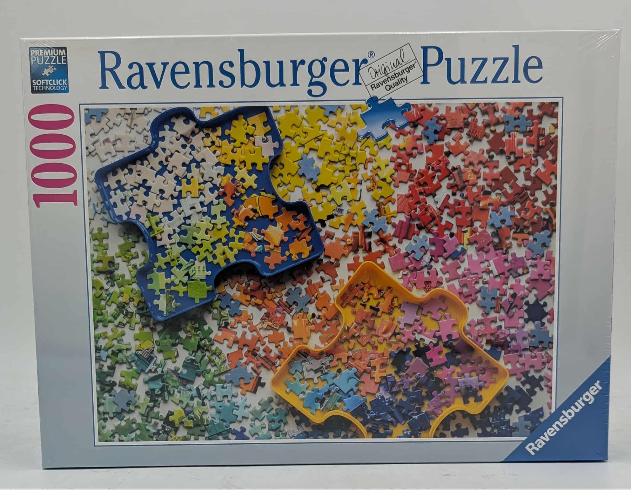 Schachtel eines Ravensburger Puzzles mit 1000 Teilen. Puzzleteile in Blau, Gelb, Orange, Grün, Rosa und Rot sind sichtbar.