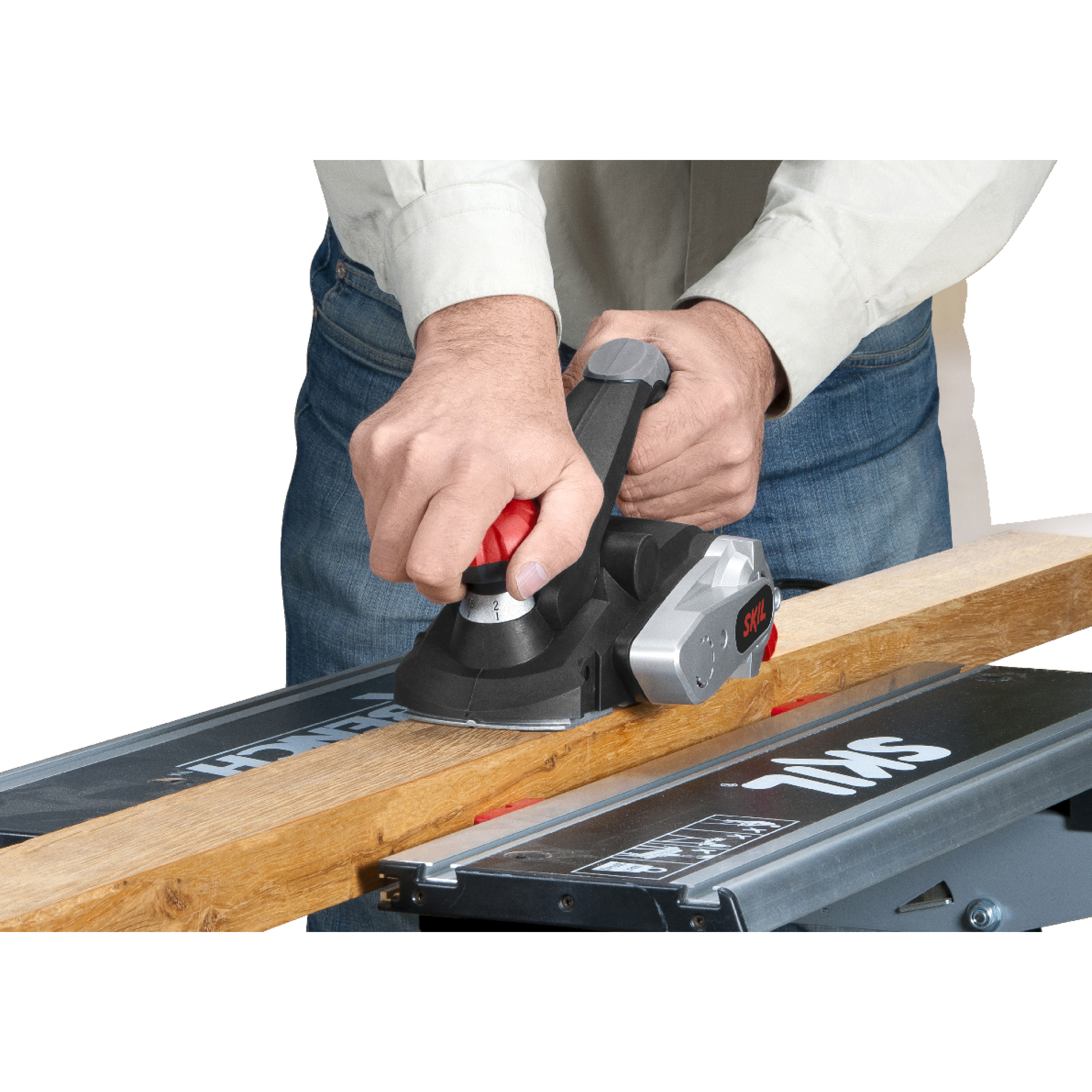 Osoba używa strugarki elektrycznej do wygładzania drewnianej deski. Narzędzie jest czarno-srebrne, deska jasnobrązowa.