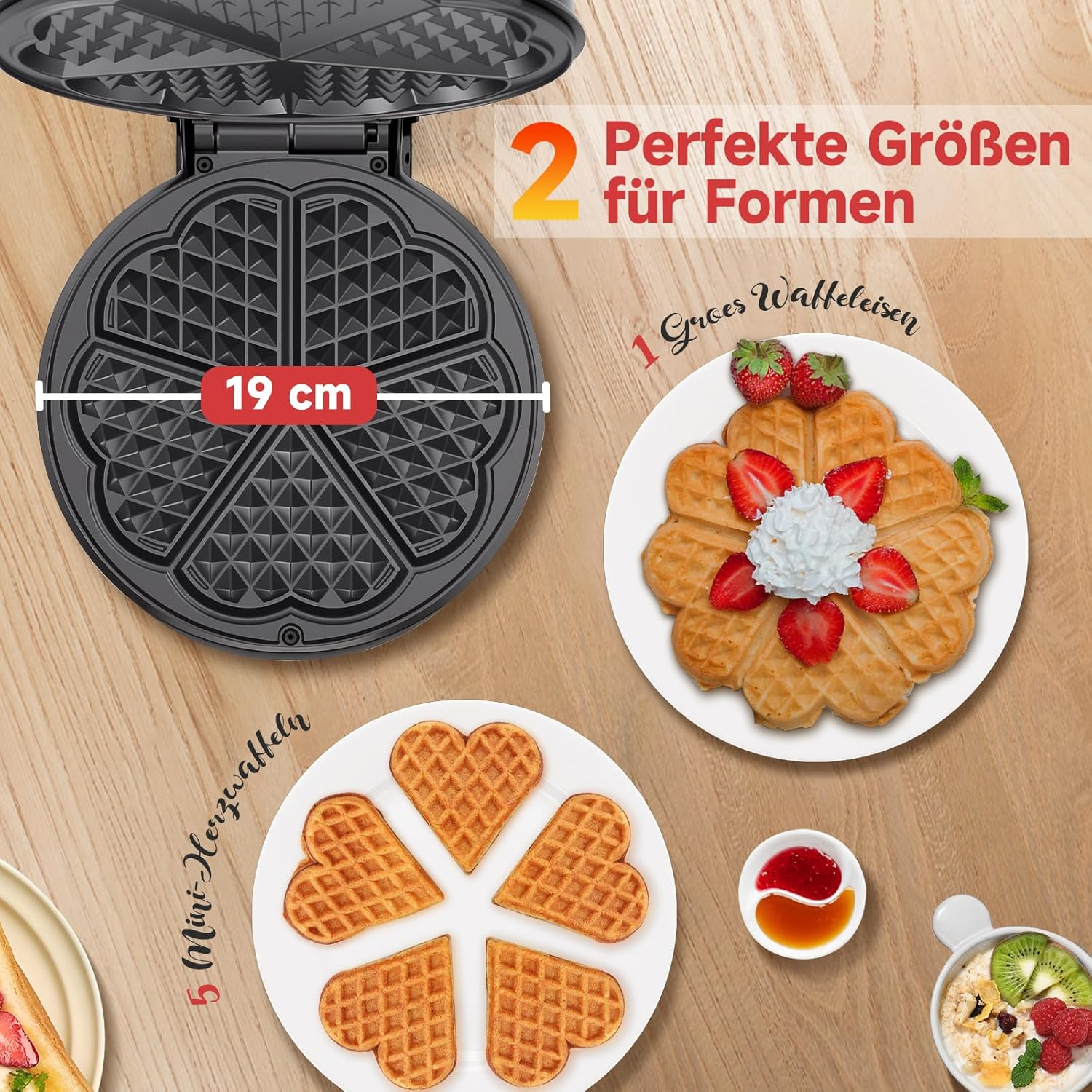 Waffeleisen, herzförmige Waffeln mit Erdbeeren und Mini-Herz-Waffeln auf einem Holztisch.