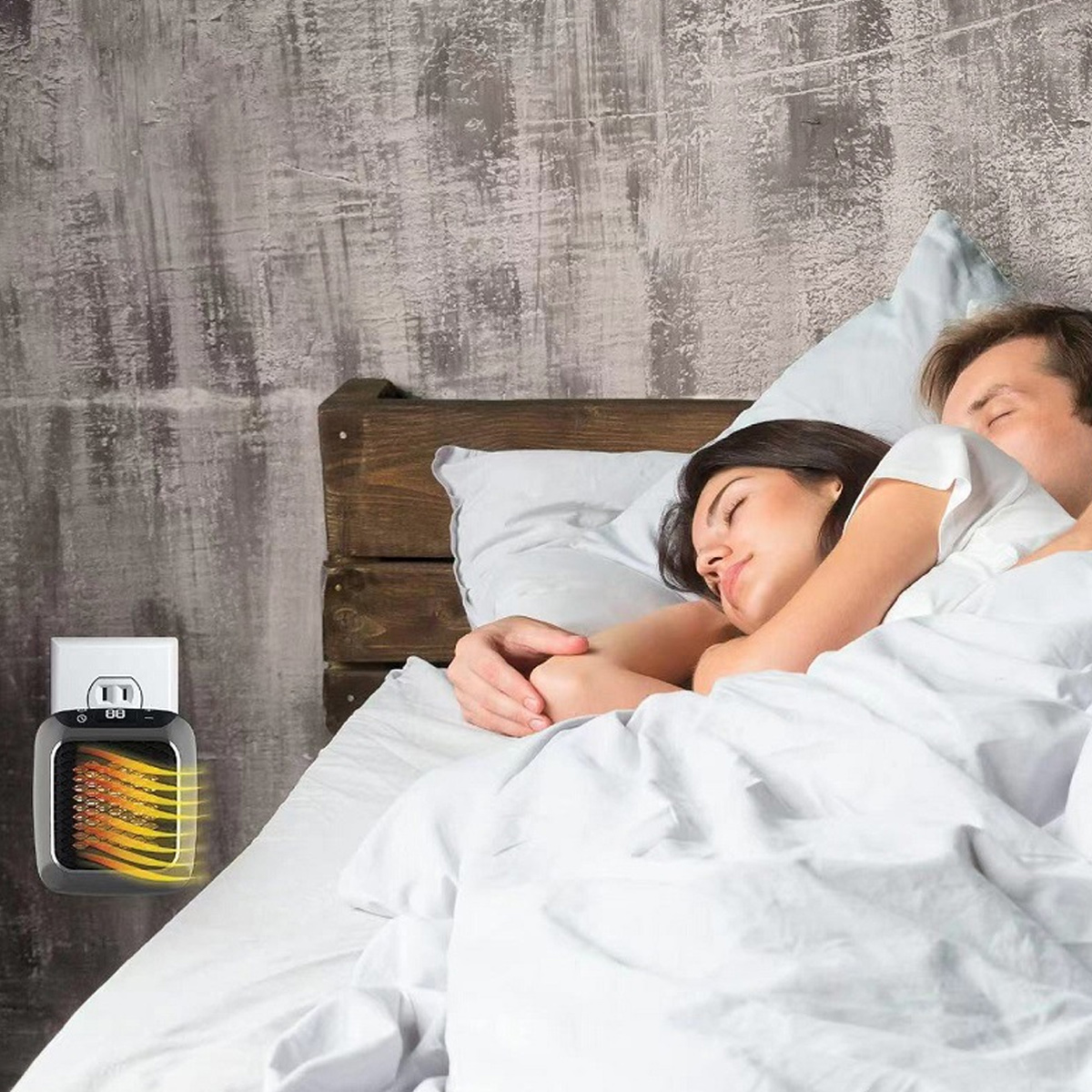 Ein Paar schläft im Bett. Ein kleiner Heizlüfter, der an der Wand eingesteckt ist, befindet sich in der Nähe des Bettes. Die Wand ist grau. Weiße Laken bedecken das Bett.
