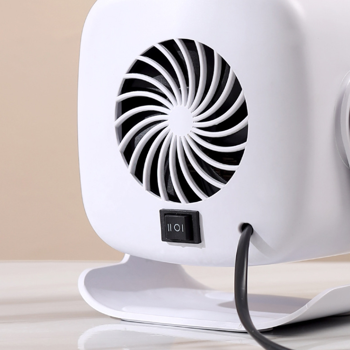 Weißes Elektrogerät mit Ventilator. Der Ventilator hat ein spiralförmiges Design. Es hat einen schwarzen Schalter und ein schwarzes Netzkabel. Der Hintergrund ist beige.