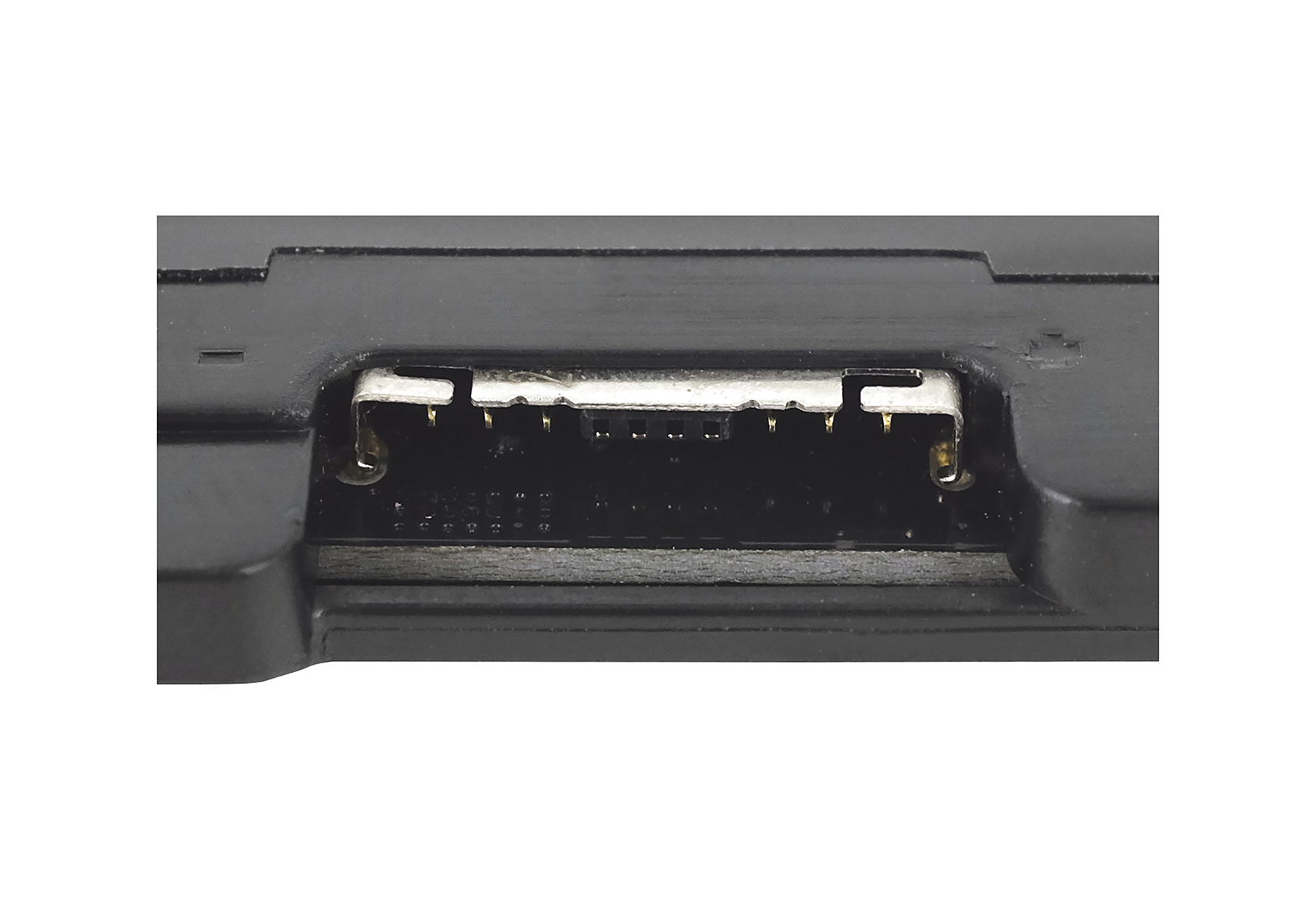 Primo piano di un componente elettronico nero, con connettore argentato a più pin, su sfondo bianco.