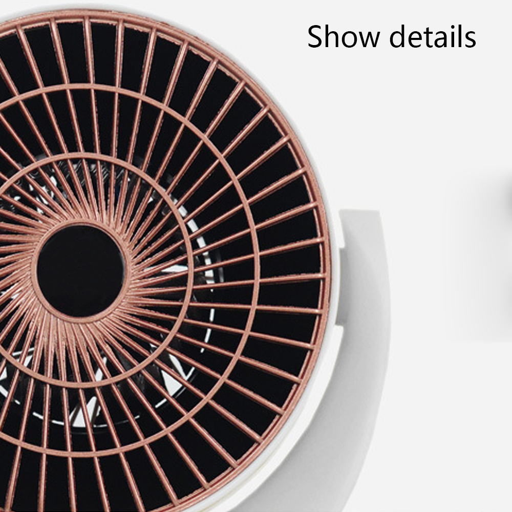 Nahaufnahme eines kleinen Ventilators. Er hat ein kupferfarbenes Gitter mit schwarzem Mittelteil. Der Sockel ist weiß.