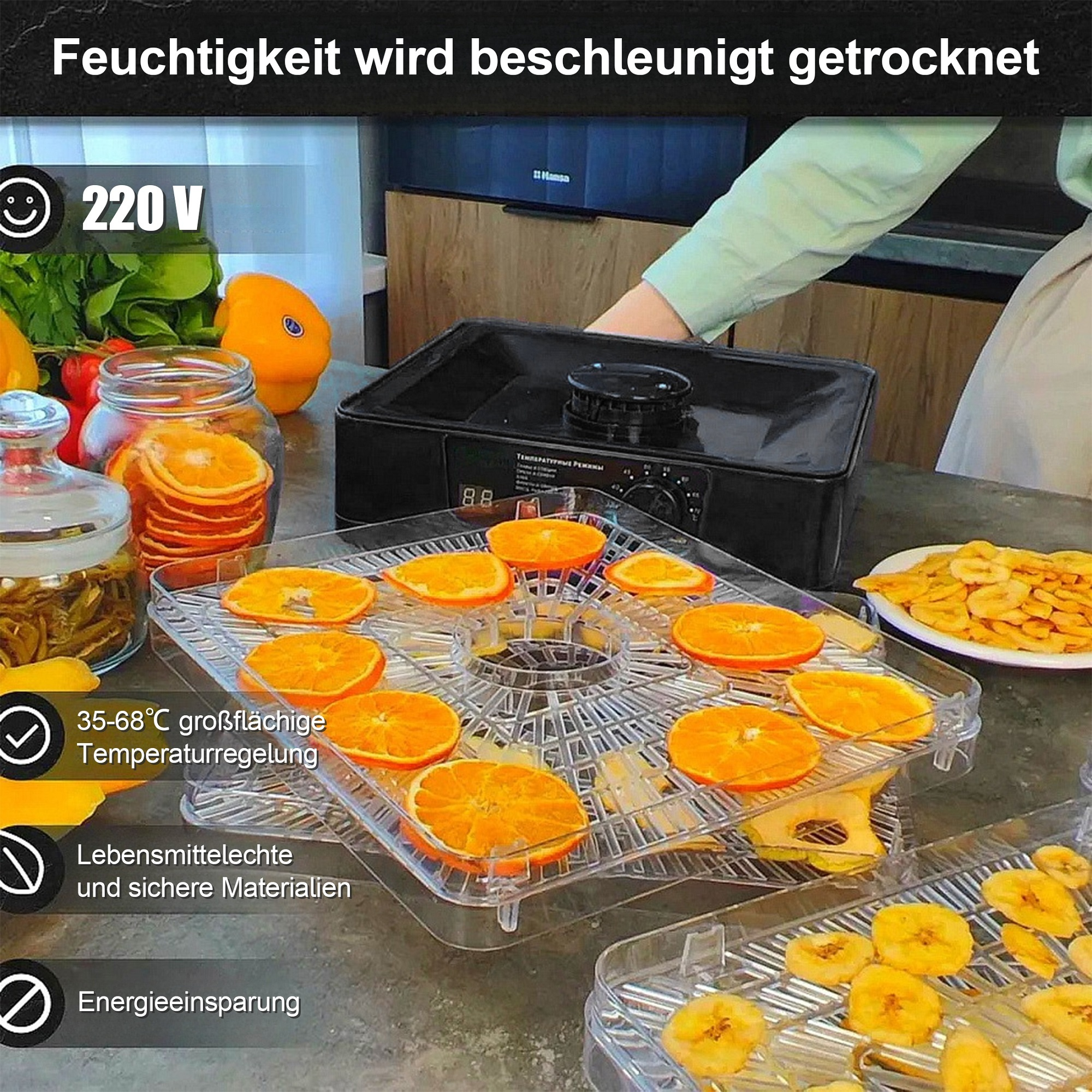 Ein Dörrautomat mit Orangenscheiben und Bananenchips. Die Maschine hat eine Temperaturregelung. Im Hintergrund ist eine Küche zu sehen.