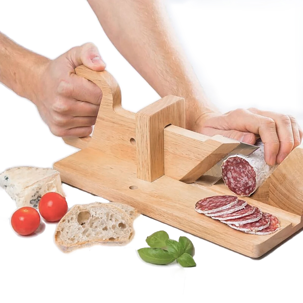 Eine Person schneidet Salami mit einem Holzschneider. Tomaten, Käse, Brot und Basilikum sind auf einer weißen Oberfläche angeordnet.